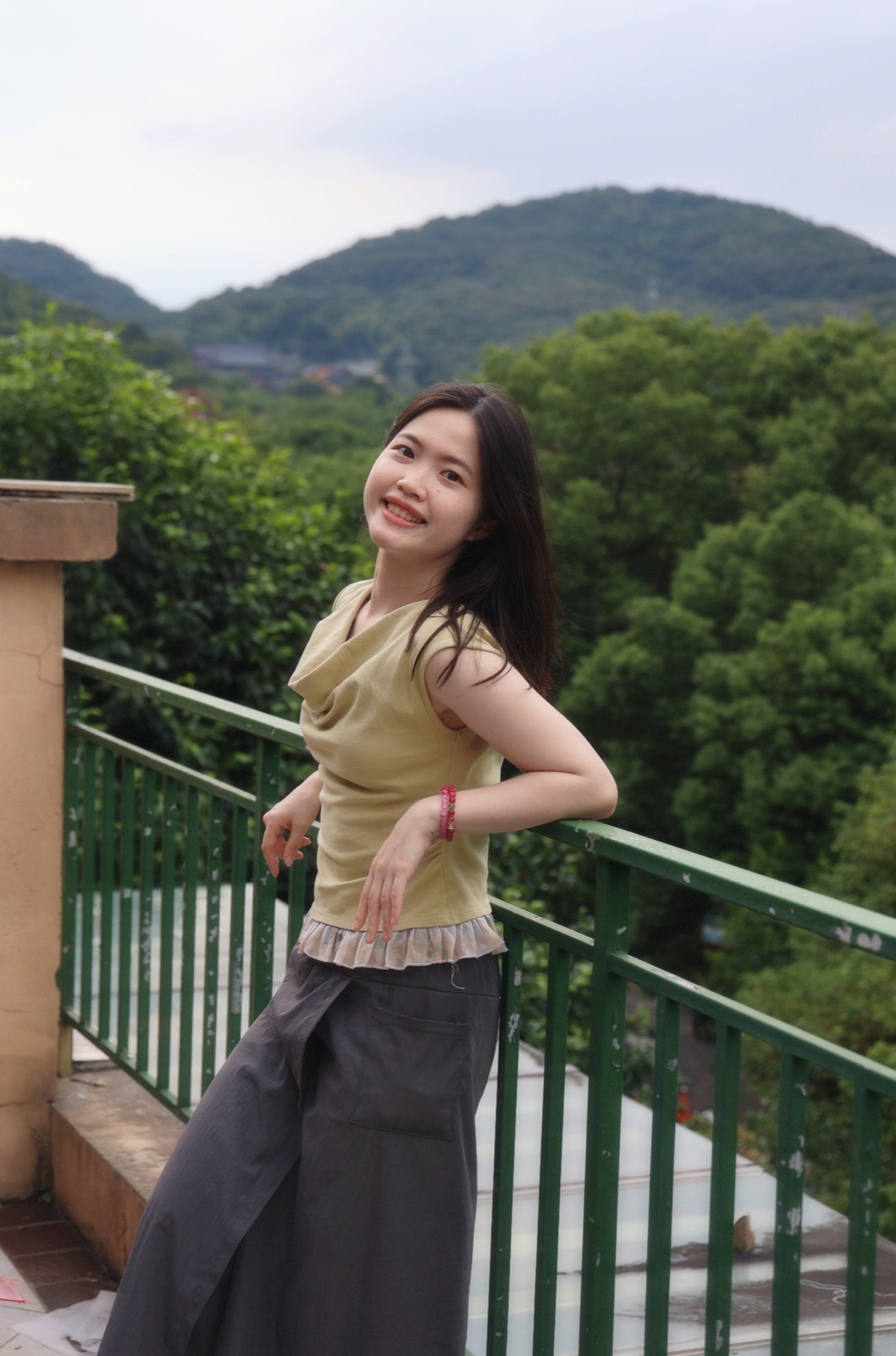Portrait of Huiling Pan in front of a mountain landscape